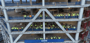 construction workers standing on multiple floors of building under construction